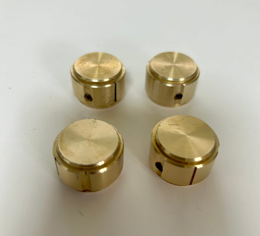 Four gold knobs on a white background