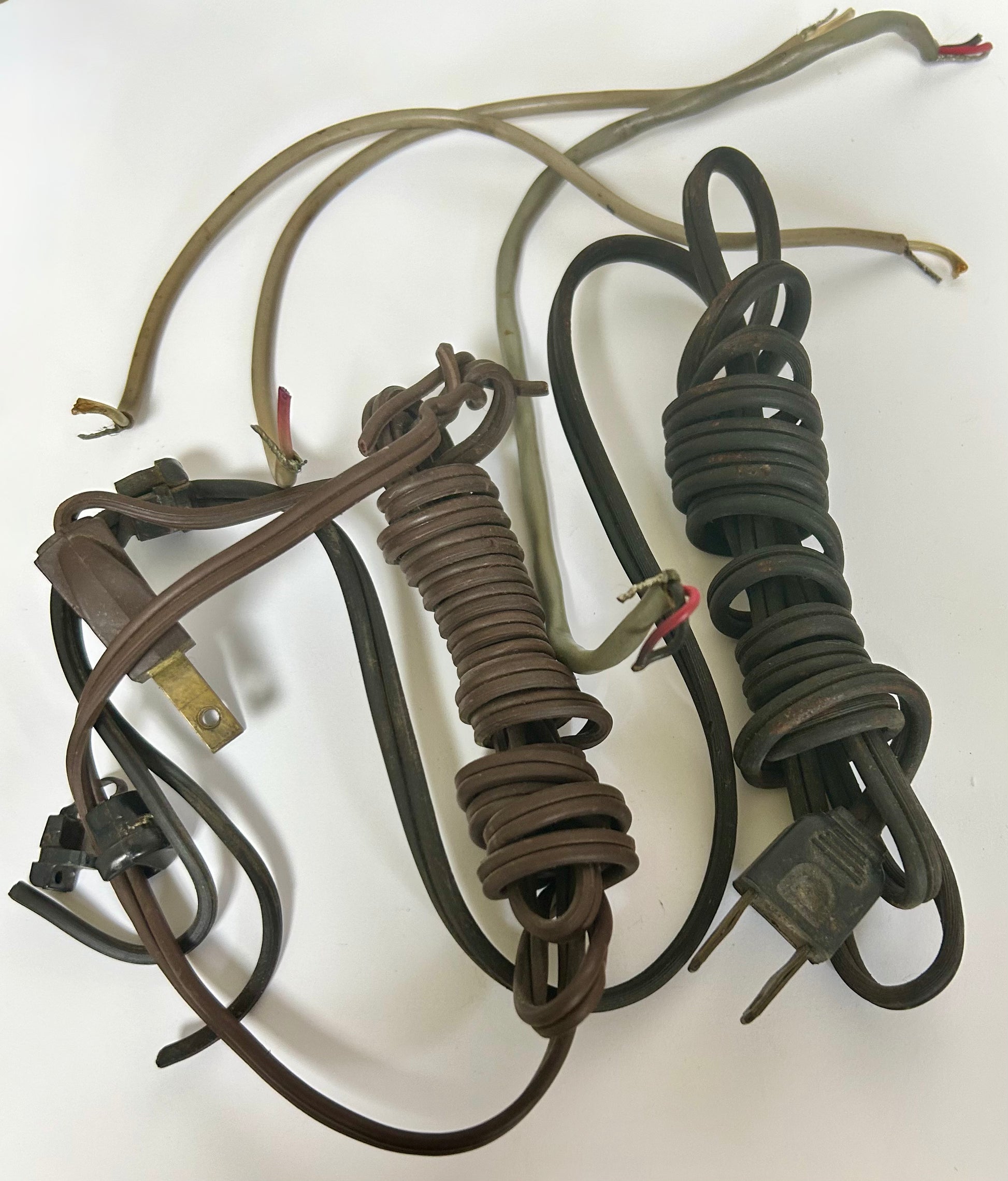 Coiled electrical cords with plugs on a white background
