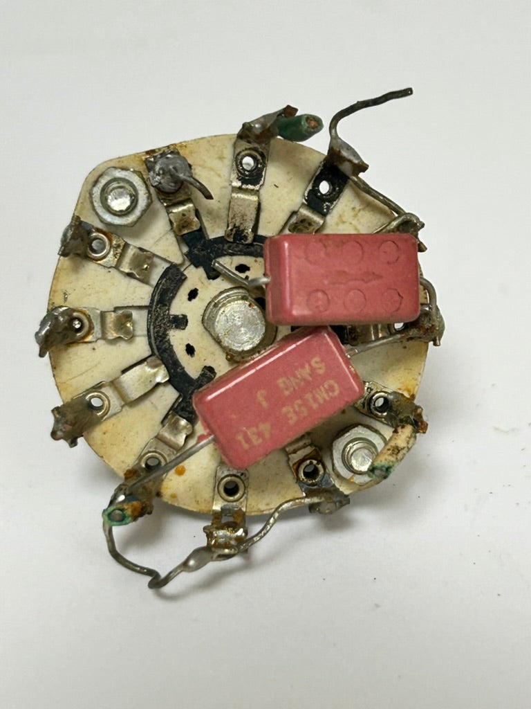 Mechanical component with red capacitors on a white background