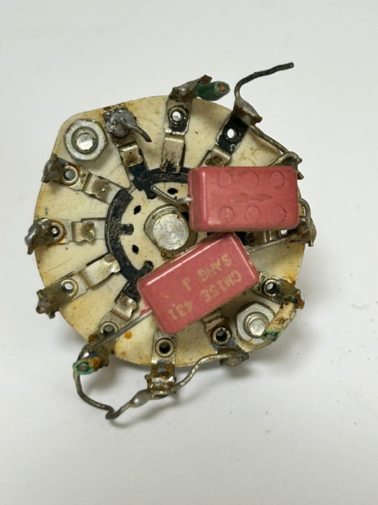 Mechanical component with red capacitors on a white background