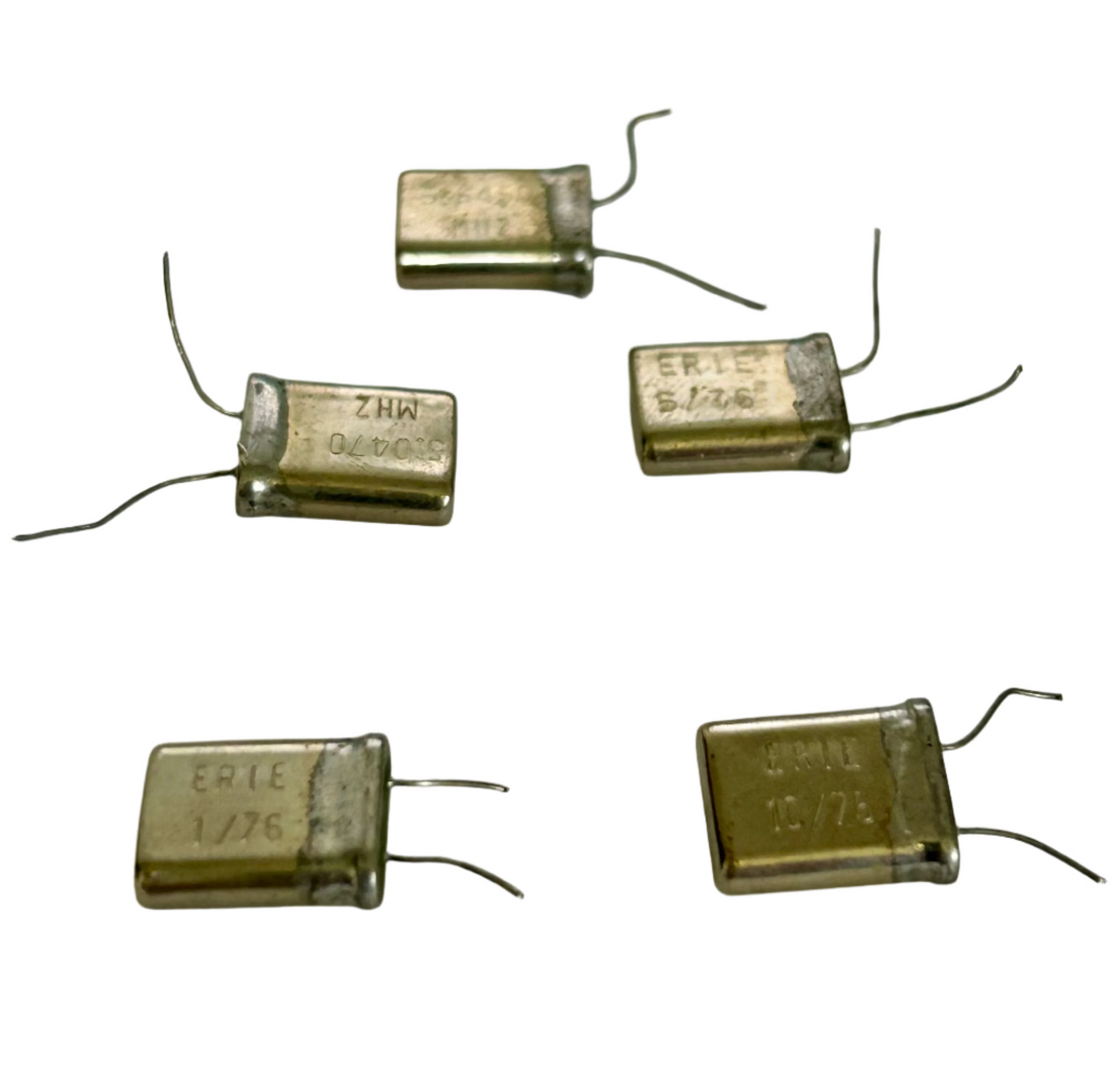Six electronic capacitors on a white surface