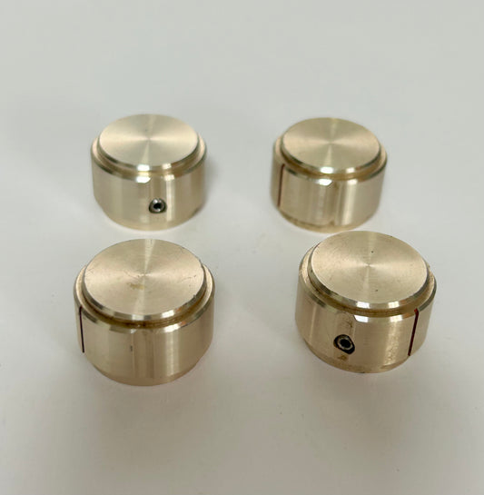Four gold-colored knobs on a white background