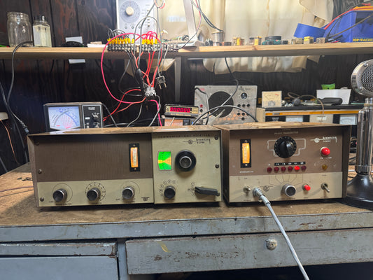 Vintage electronic equipment on a workbench with wires and tools in the background