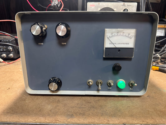 Vintage electronic device with knobs and a meter on a wooden surface